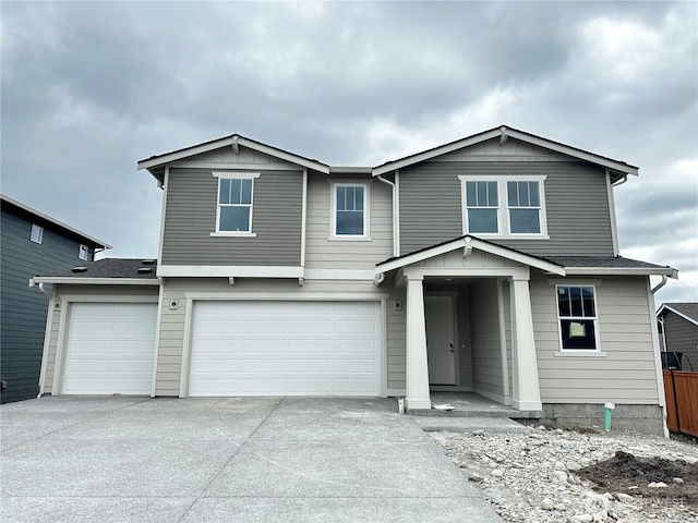 view of front of property featuring concrete driveway, a garage, and fence