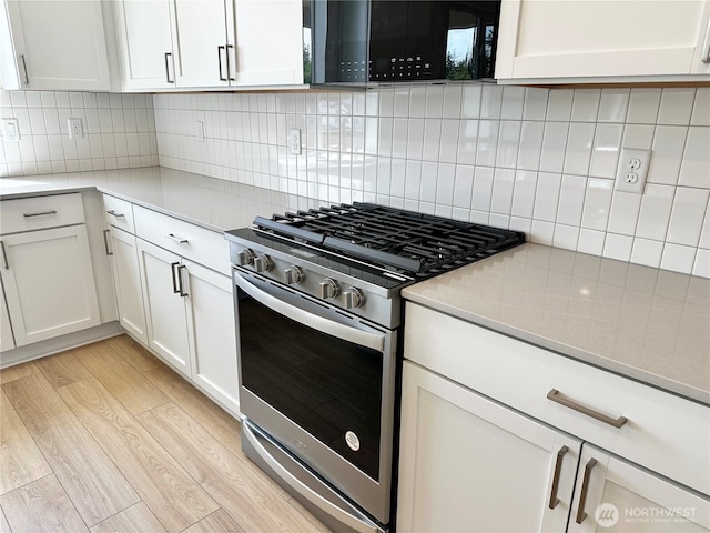 13414 187th Street Ct E Unit 20, Puyallup, WA 98374 - kitchen featuring stainless steel gas range, black microwave, light countertops, and white cabinetry