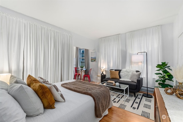 bedroom with wood-type flooring and baseboard heating