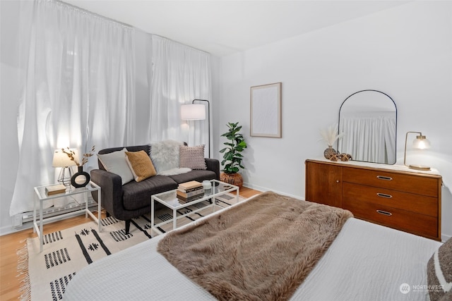 bedroom featuring baseboard heating and light hardwood / wood-style floors