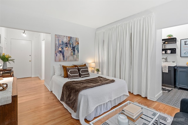 bedroom featuring sink and light wood-type flooring