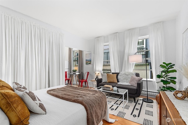 bedroom featuring hardwood / wood-style floors and baseboard heating