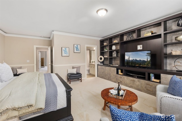 bedroom with ornamental molding, connected bathroom, and carpet