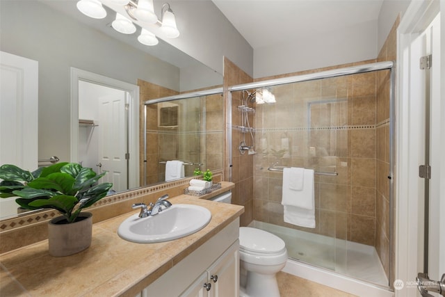 bathroom featuring a shower with door, vanity, an inviting chandelier, and toilet