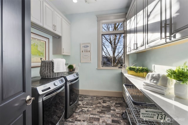 washroom with cabinets and washer and clothes dryer