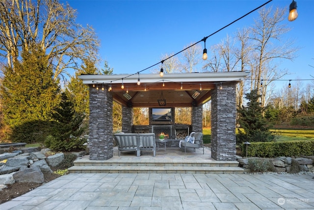 view of patio featuring a gazebo and an outdoor living space with a fireplace