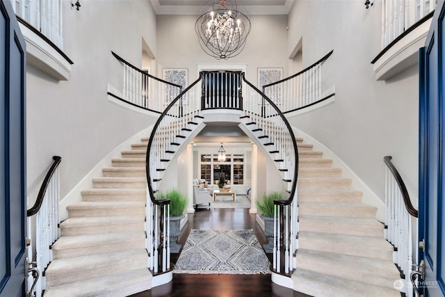 entryway featuring crown molding, hardwood / wood-style flooring, a chandelier, and a high ceiling