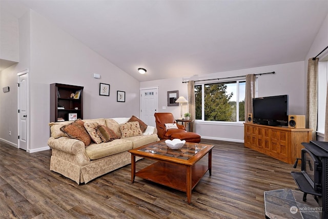 living room featuring vaulted ceiling, dark wood-type flooring, and a wood stove