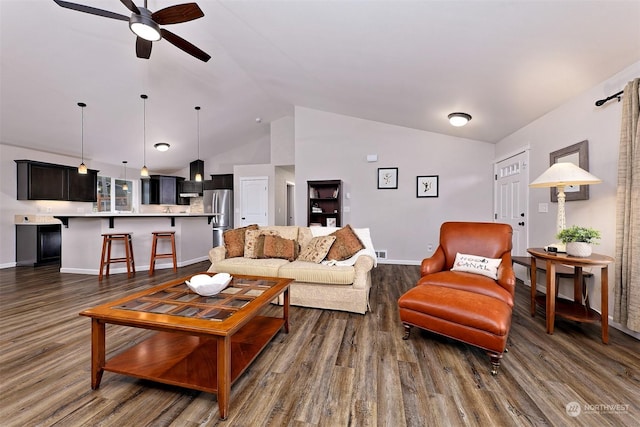 living room featuring dark hardwood / wood-style flooring, vaulted ceiling, and ceiling fan