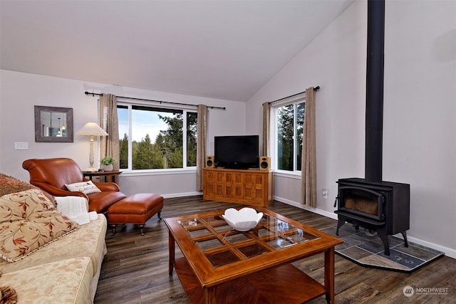 living room featuring vaulted ceiling, a wood stove, and dark wood-type flooring