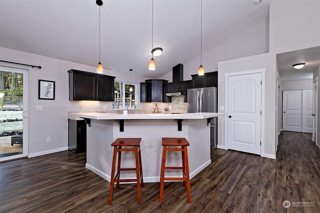 kitchen featuring a breakfast bar area, decorative light fixtures, a center island, a wealth of natural light, and backsplash