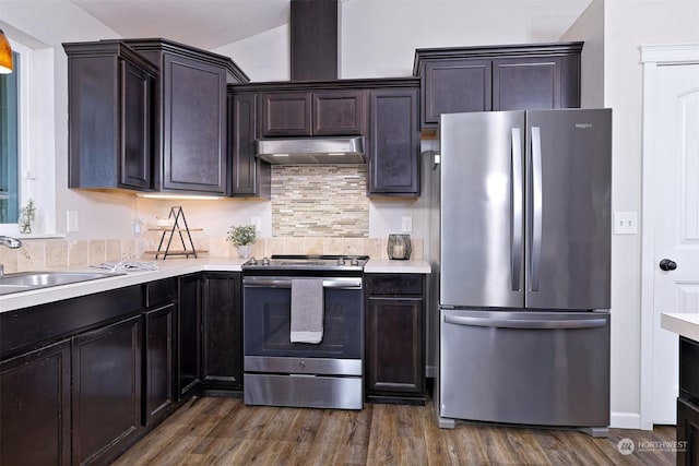 kitchen with vaulted ceiling, sink, dark brown cabinetry, stainless steel appliances, and dark wood-type flooring