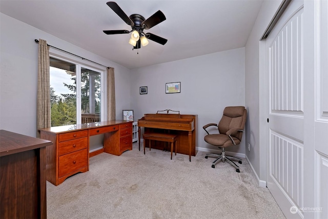 carpeted office space with ceiling fan