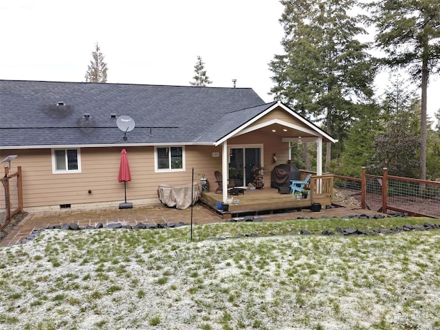 rear view of house with a deck and a lawn