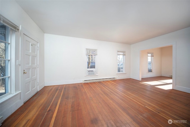 empty room with hardwood / wood-style floors, baseboards, and baseboard heating