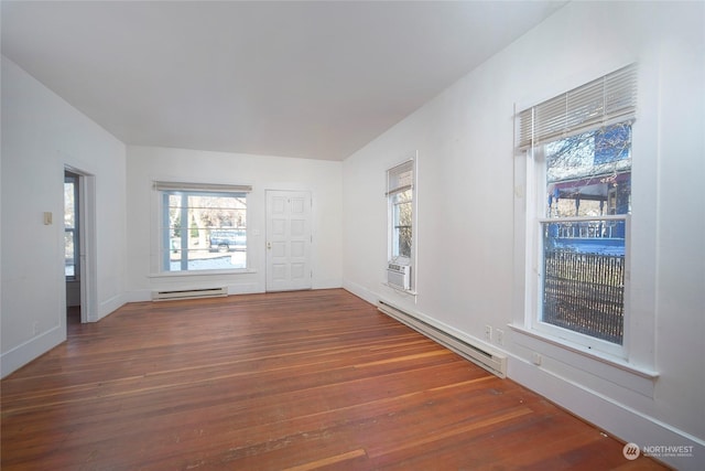 spare room featuring cooling unit, a baseboard radiator, wood finished floors, and baseboards