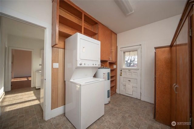 laundry area featuring stacked washer and dryer, laundry area, and electric water heater