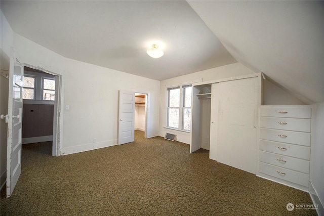 unfurnished bedroom with carpet, lofted ceiling, and baseboards