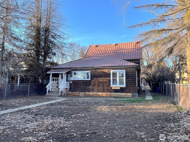 view of front of property featuring fence and metal roof