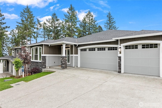 6612 6th St E, Tacoma, WA 98424 - view of front facade with board and batten siding, a garage, stone siding, concrete driveway, and roof with shingles