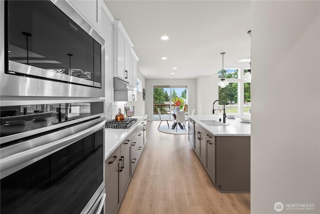 6612 6th St E, Tacoma, WA 98424 - kitchen featuring appliances with stainless steel finishes, a sink, light countertops, light wood-type flooring, and recessed lighting