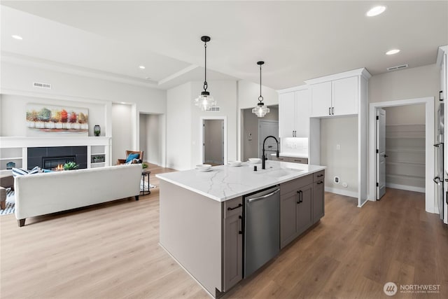 6612 6th St E, Tacoma, WA 98424 - kitchen featuring stainless steel appliances, a sink, open floor plan, light wood-type flooring, and light stone counters