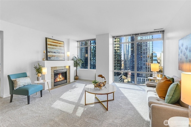 living room with a fireplace with flush hearth, carpet, baseboards, and expansive windows