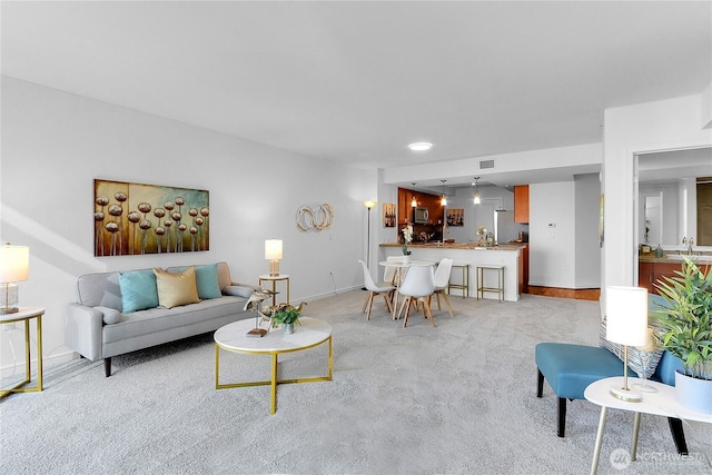 living area with light colored carpet and baseboards