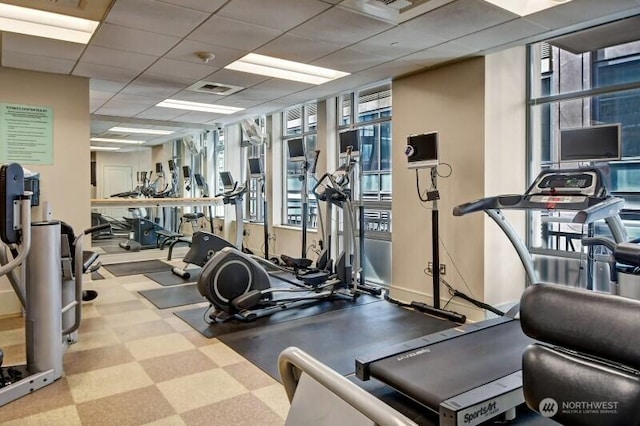 gym with a paneled ceiling and visible vents