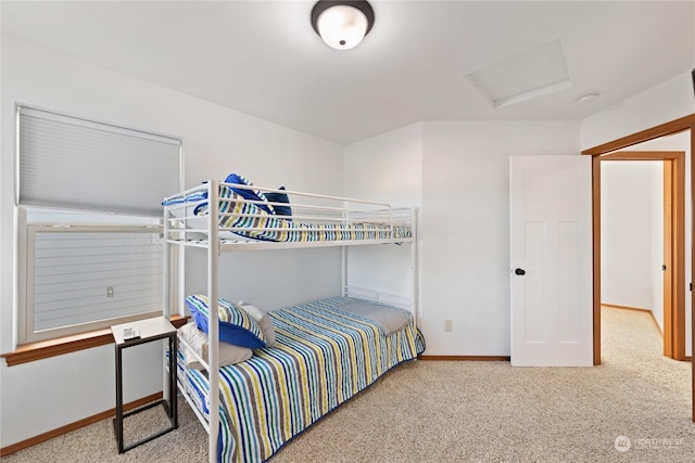 carpeted bedroom with baseboards and attic access