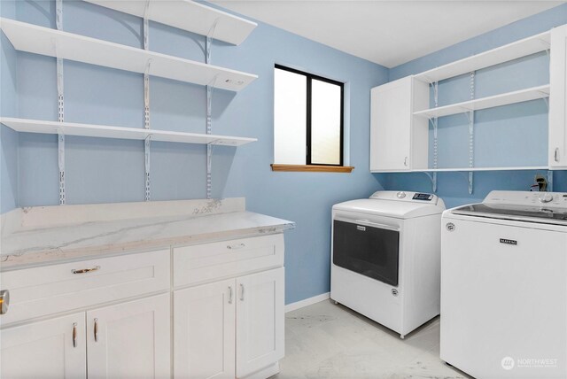 laundry area featuring washer and clothes dryer and cabinets