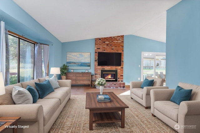 living room featuring wood-type flooring, a fireplace, vaulted ceiling, and a wealth of natural light