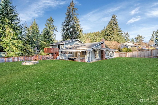 rear view of property featuring a wooden deck and a lawn