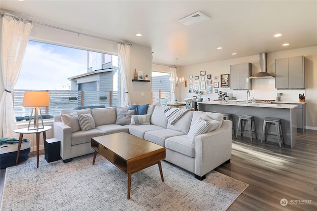 living room with sink, a chandelier, and light wood-type flooring