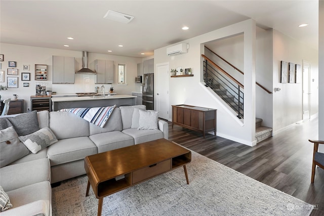 living room featuring a wall mounted air conditioner and dark hardwood / wood-style floors