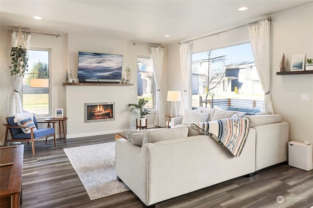 living room featuring dark wood-type flooring and a healthy amount of sunlight