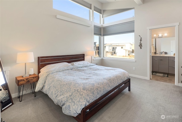 carpeted bedroom featuring multiple windows and a high ceiling