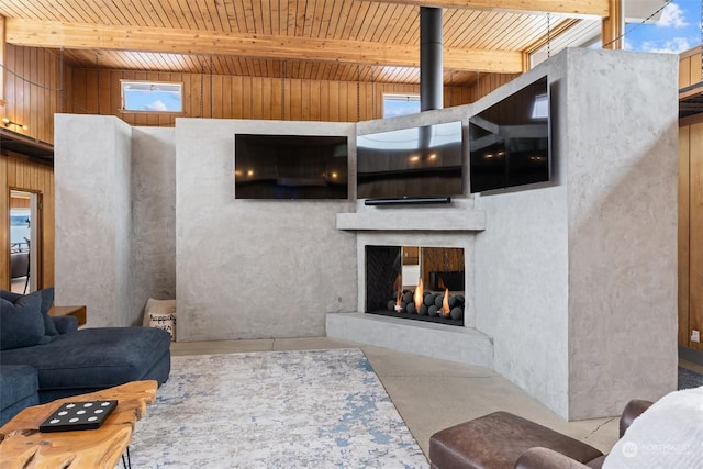 living room featuring a multi sided fireplace, wooden ceiling, concrete floors, beamed ceiling, and wood walls