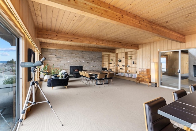 interior space with a fireplace, wooden walls, and carpet flooring