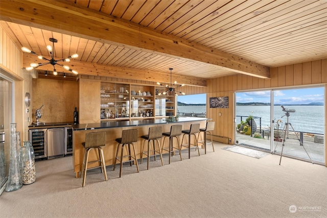 bar with wooden walls, beamed ceiling, a chandelier, and a water view