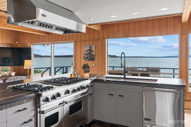 kitchen with stainless steel appliances, white cabinetry, a water view, and exhaust hood