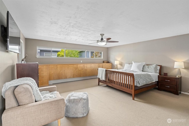 bedroom featuring light carpet, a baseboard heating unit, and ceiling fan