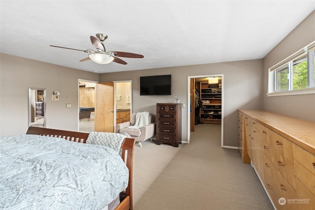 bedroom with a walk in closet, light carpet, ceiling fan, and a closet