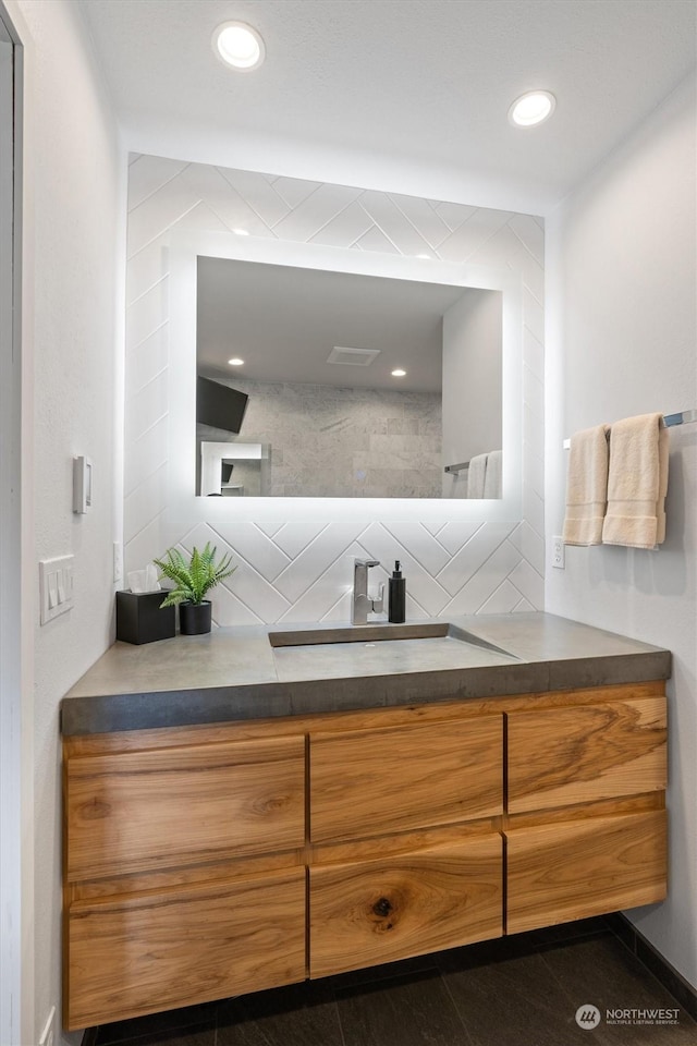 bathroom featuring tasteful backsplash and vanity