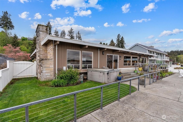 rear view of house featuring a hot tub