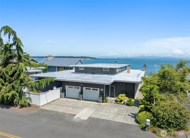 1267 Beach Dr, Camano Island, WA 98282 - view of front of property featuring a water view, driveway, a garage, and a chimney