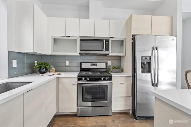 kitchen with white cabinetry, appliances with stainless steel finishes, dark hardwood / wood-style flooring, and decorative backsplash