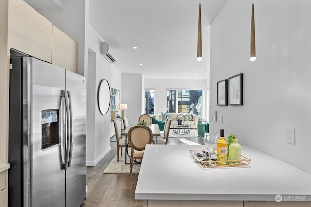 kitchen featuring dark hardwood / wood-style flooring, stainless steel fridge with ice dispenser, and an AC wall unit