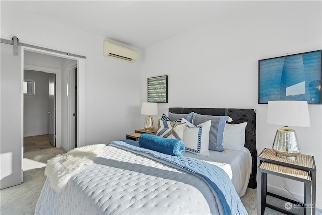 carpeted bedroom with a wall mounted air conditioner and a barn door