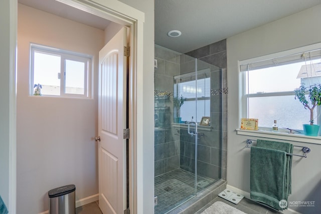 bathroom with plenty of natural light and a shower with door